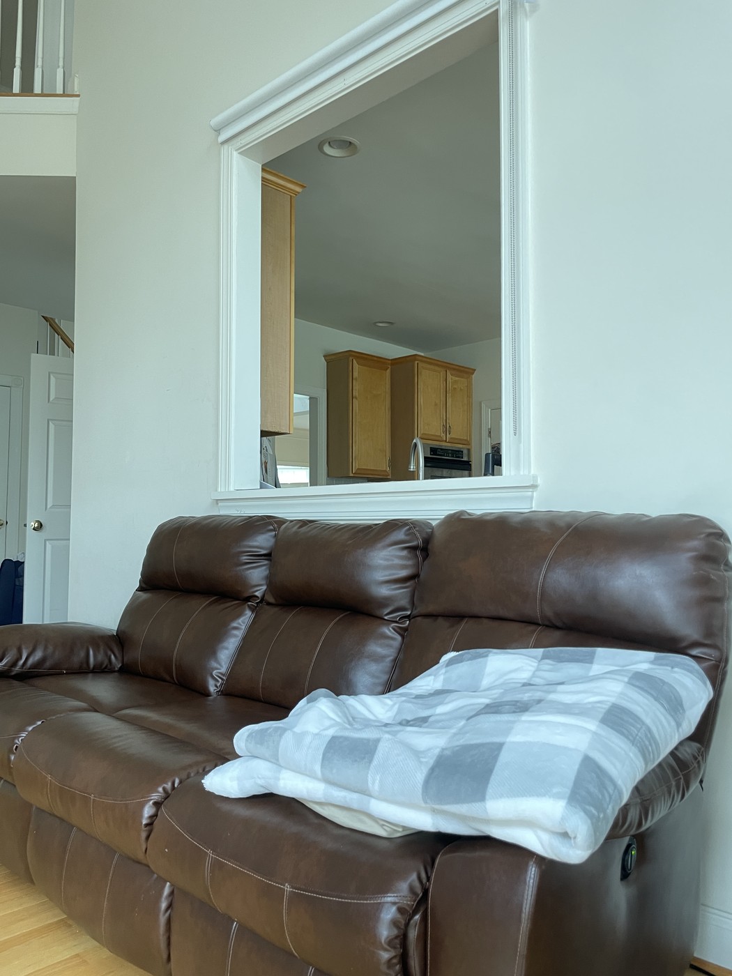 Open wall cutout above the couch with no covering, before