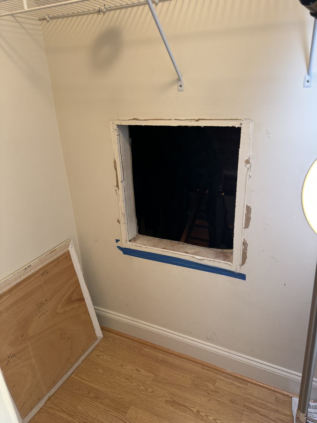 Open unfinished wall cutout in a closet, before