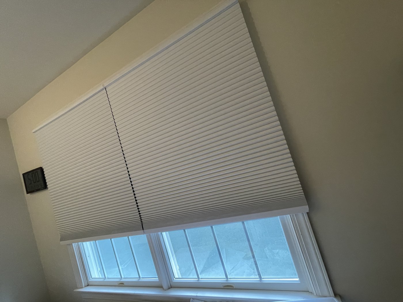 Same office window with blackout shade lowered, glare removed, after