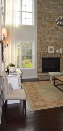 Floor-to-ceiling sheer drapes beside a stone fireplace
