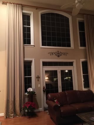 Floor-to-ceiling drapes on a two-story window wall