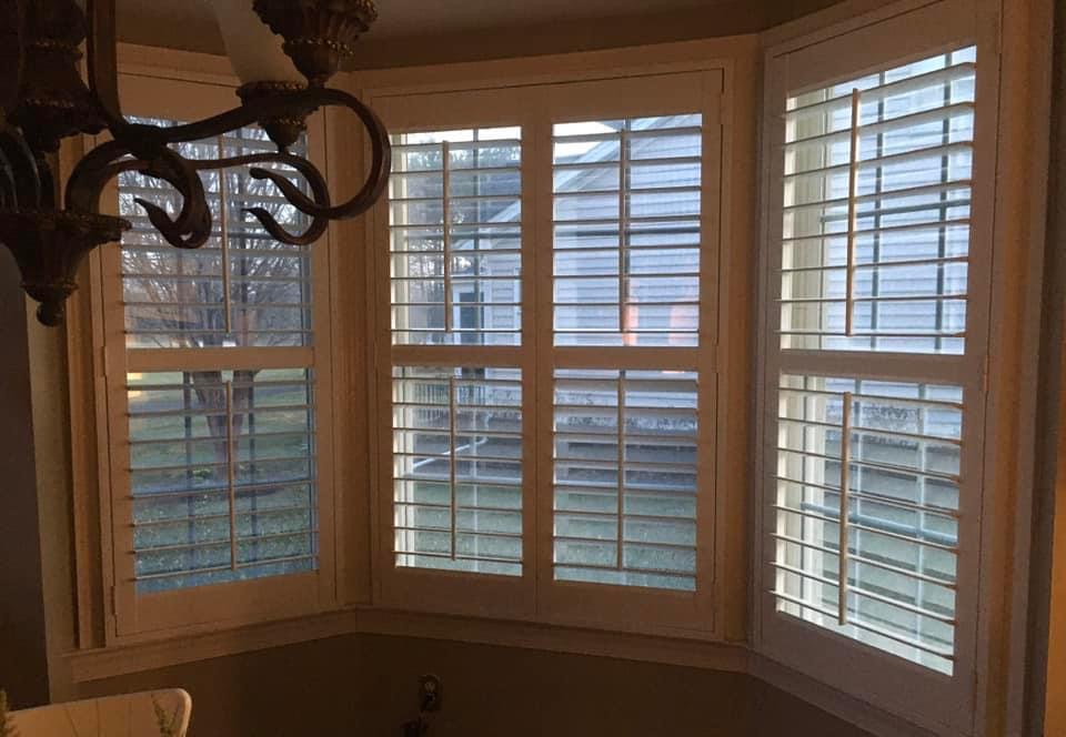 White louvered shutters on a three-sided bay window