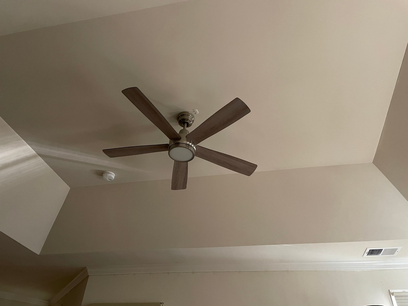 New ceiling fan with a light kit installed on the vaulted ceiling, after