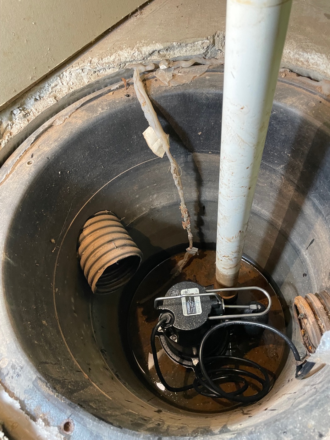 Basement sump pit with the new pump installed, after